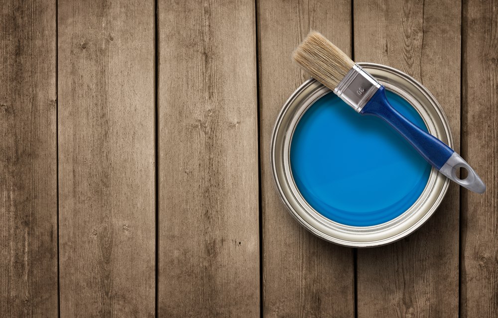 Photo d'un pot de peinture bleu sur des lames de parquet